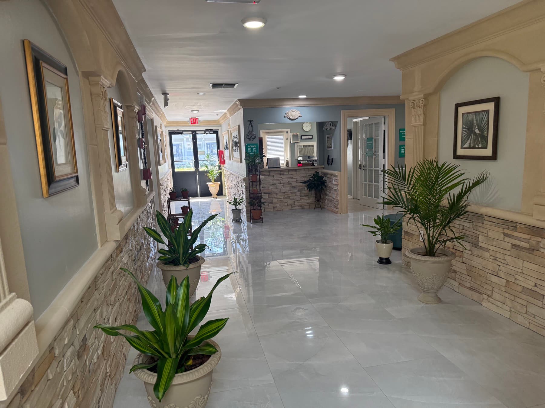 Entrance hall with stone accent walls, potted palms and the front desk