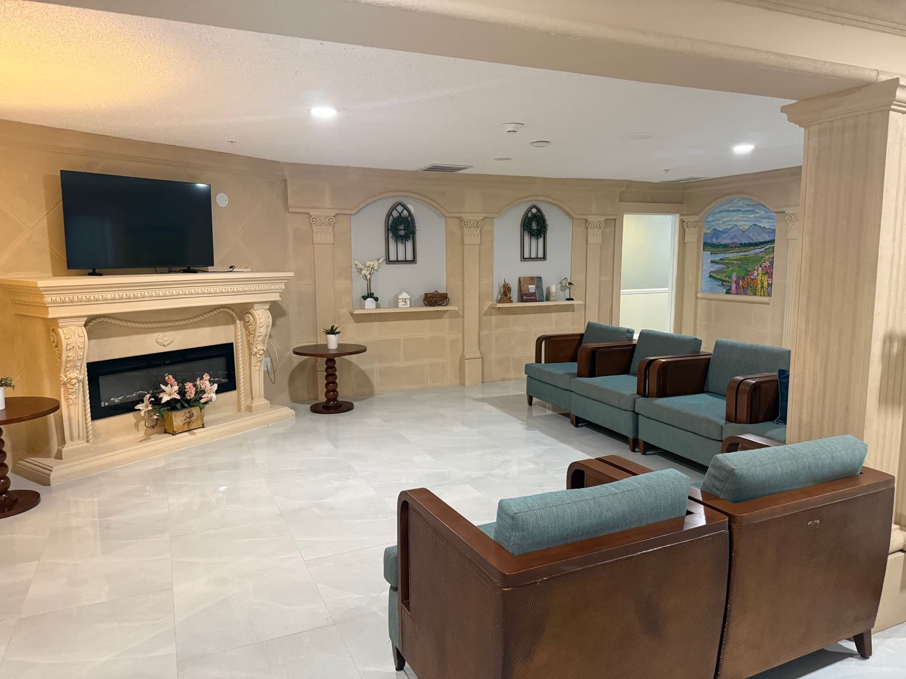 Lounge with fireplace, arched alcoves, a mountain mural and comfortable seating